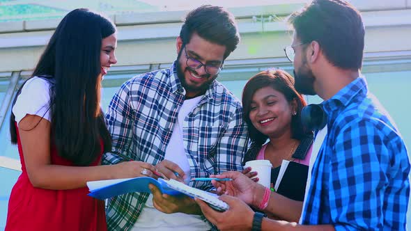 Indian Friends Sitting on Stairs Outdoors with Copybooks