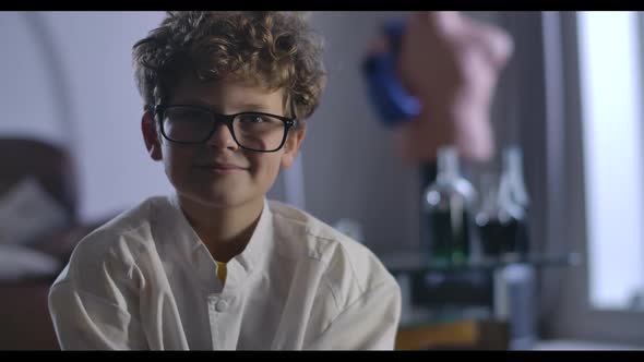 Portrait of Smart Caucasian Boy in Eyeglasses Looking at Camera and Smiling. Close-up of Intelligent