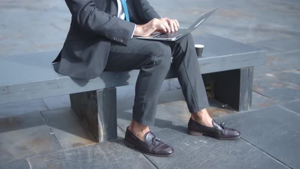 Serious Bald Businessman Typing on Laptop