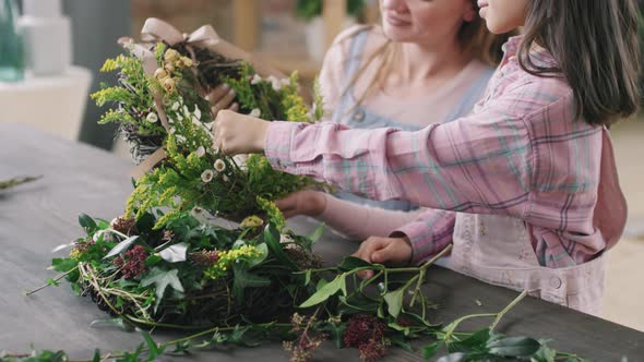 Woman and Girl Making Flower Wreath