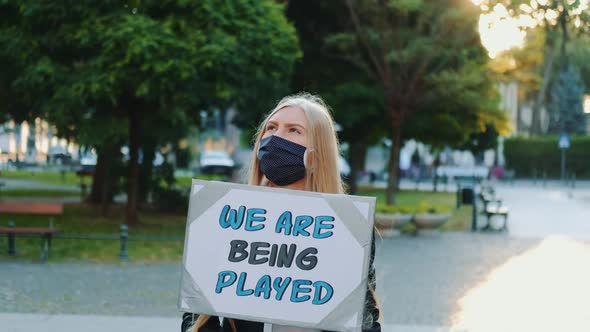 Pretty Girl Wearing Medical Mask Protesting Against Authorities That Playing Human Lives
