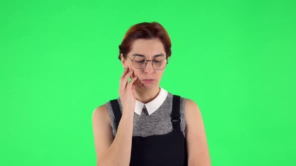 Portrait of Funny Girl in Round Glasses Is Focused Thinking About Something, No Idea. Green Screen