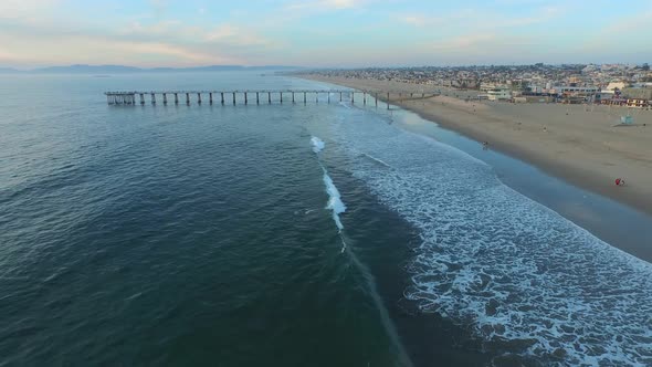 Aerial shot of a scenic beach city and ocean at sunset.