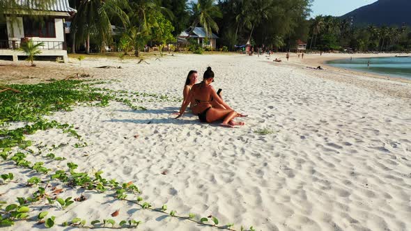 Sexy happy ladies on holiday by the sea on beach on summer white sand and blue background 4K