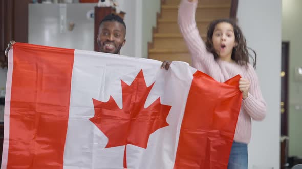 Happy Cheerful African American Man and Teen Girl Holding Canadian Flag Rejoicing Hockey Team