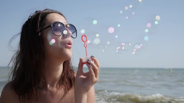 Slow motion of young Caucasian brunette blowing soap bubbles  1920X1080 HD video - Outdoor female pl