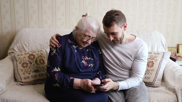 Grandson shows grandmother photos on the phone