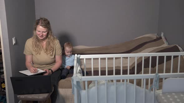 Self-isolation of family life. Mom works at home with a laptop, distracted by her child.