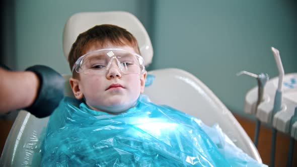 A Little Boy Having His Teeth Done - Putting on Safety Cover and Glasses