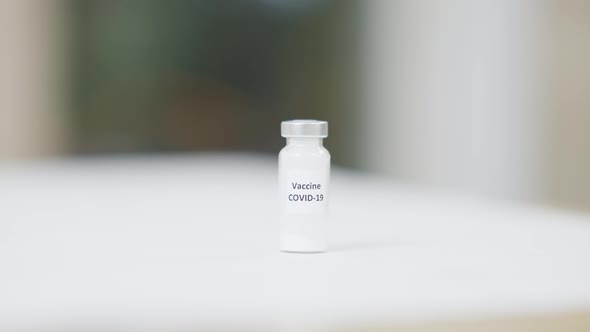 Covid19 Vaccine Ampoule Standing on Table in Medical Cabinet