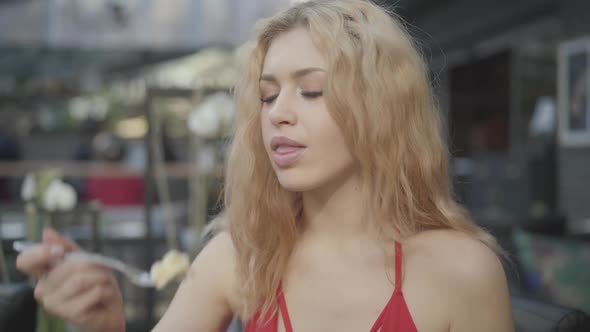 Portrait Cute Blond Woman with Curly Hair Eating Cake in the Restaurant Close Up. Hot Lady with Deep