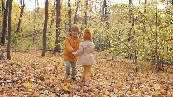 Happy Kids with Little Kids in Autumn Park on Sunny Day