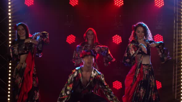 Three Adorable Woman and One Man are Dancing in Gypsy Costumes