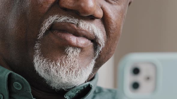 Closeup Unrecognizable Elderly Biracial Old Man with Grey Beard Holding Telephone Typing Text