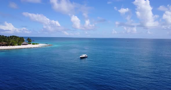 Wide overhead copy space shot of a sandy white paradise beach and aqua blue ocean background in vibr