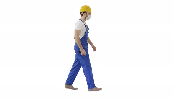 Construction Worker Wearing a Hardhat and Mask Walking on White Background. alt