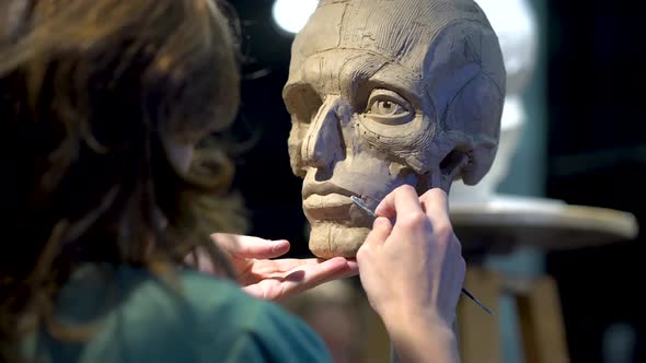 Woman Sculptor at Work on a Sculpture of a Human Head