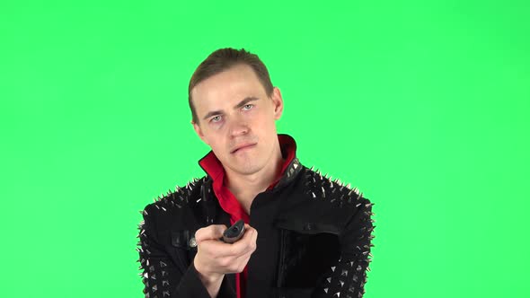 Guy with TV Remote in His Hand, Switching on TV. Green Screen