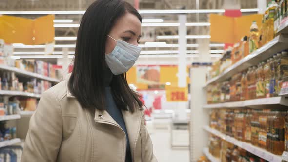 Young Woman in Medical Mask Selects Food in Supermarket, Protection Coronavirus Pandemic Covid-19 in