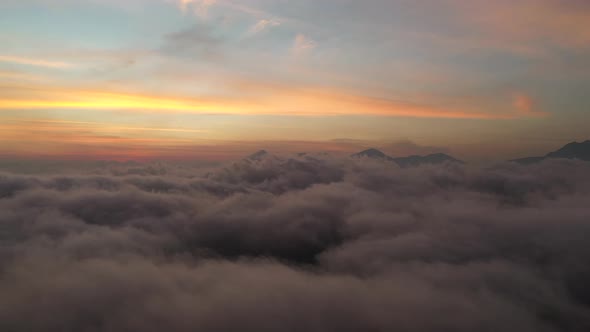 Colorful sky above the dreamy peaceful clouds over the mountain. Aerial wide angle shot. Abstract ba