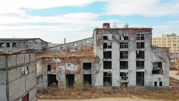 Front facade of abandoned building. Old factory shows the post industrial plight with broken windows