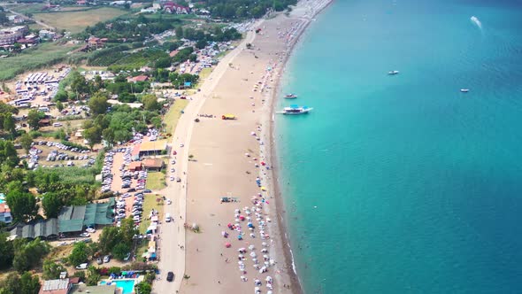 aerial top down view of the tropical blue Mediterranean coastline of Adrasan Beach full of tourists