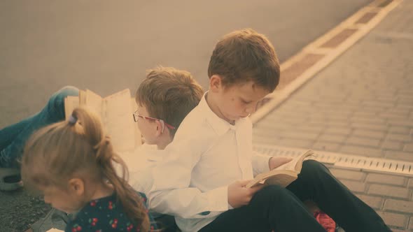 Young Serious Guys Study Outdoors Sitting on Coloured Bags