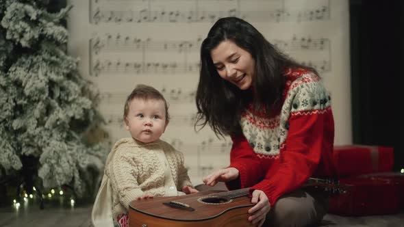 Mom Teaches Baby to Play Guitar at Xmas