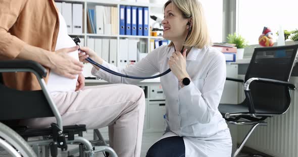 Doctor Listens to Fetal Heartbeat of Pregnant Woman in Wheelchair in Hospital