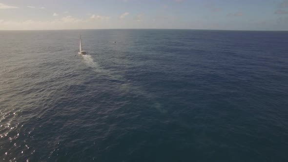 Flying Over the Yacht Sailing in Open Sea or Ocean alt