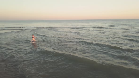 Young Sister and Brother Who Are Playing in the Sea