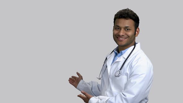 Young Darkskinned Doctor Pointing Back at Copyspace
