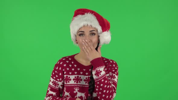 Portrait of Sweety Girl in Santa Claus Hat Is Blowing Kiss. Green Screen