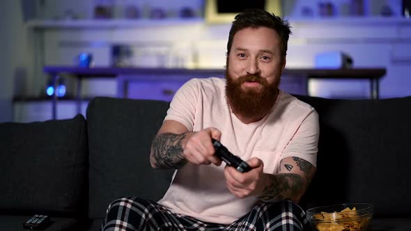 Adult man sitting on the sofa and playing video games