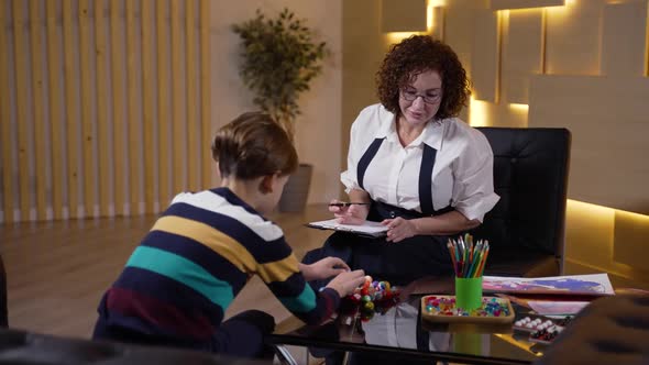 Female Psychologist Testing Boy at Consultation