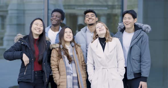 Multiracial group of college student friends portrait laughing and looking at
