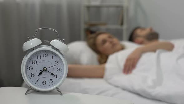 Loud Alarm Clock Signal Waking Up Sleeping Couple in Morning, Sleep Deprivation