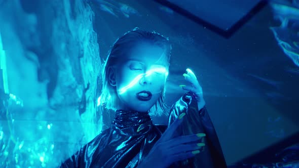 Stylish Alien Woman Posing on Camera in Blue Laser Light