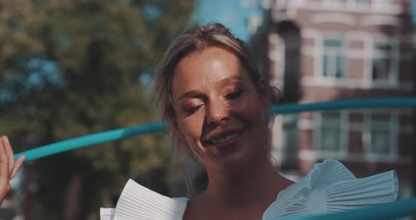 Woman smiles with Hula Hoop overhead