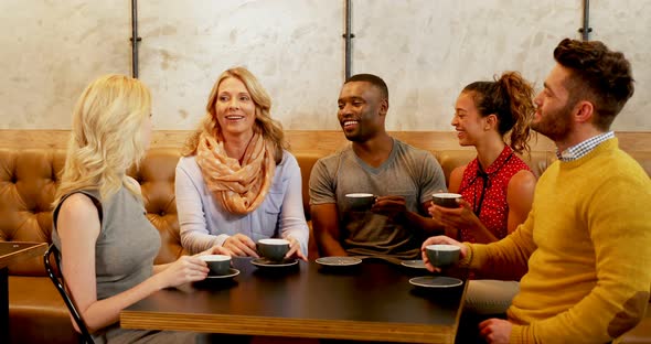 Group of happy friends interacting while having coffee 4K 4k