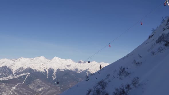 View Of Ski Lift Cable Car Lifts Skiers Against Of Snow Capped Mountains Peaks