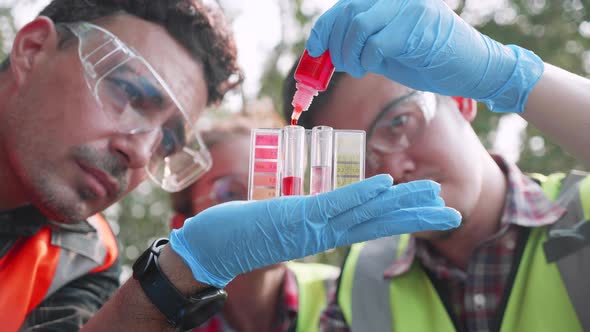 Close up of Biological engineer team checks pH value of factory wastewater by Colorimetric method.