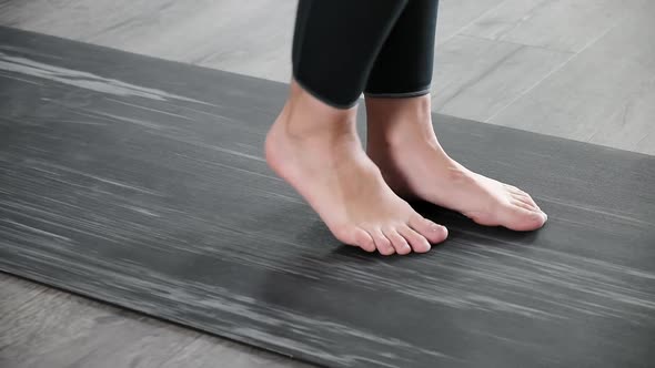 Closeup on Legs of Barefoot Woman on Mat Warming Up Preparing for Exercises