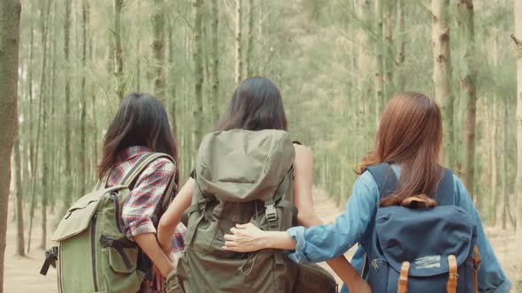 Asian hiker women trekking in forest. Young happy backpack girls walking enjoy her journey.