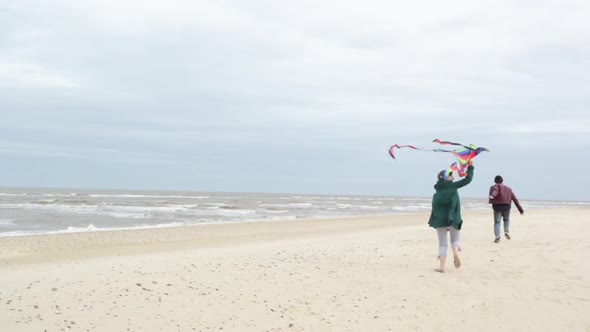 Couple flying kite by the sea