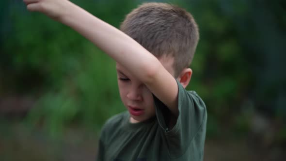 Upset Boy Wiping Tears with His Hand