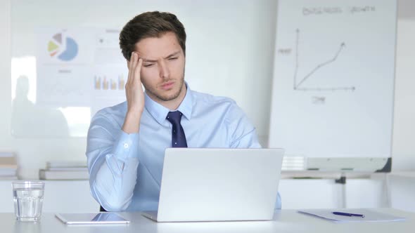 Young Businessman with Headache Working in Office