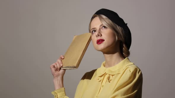 Stylish woman with a book on grey background