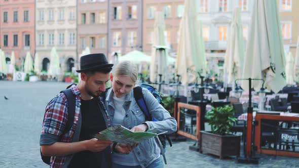 Young Man and Woman Looking on Main Tourist Attractions Using Map