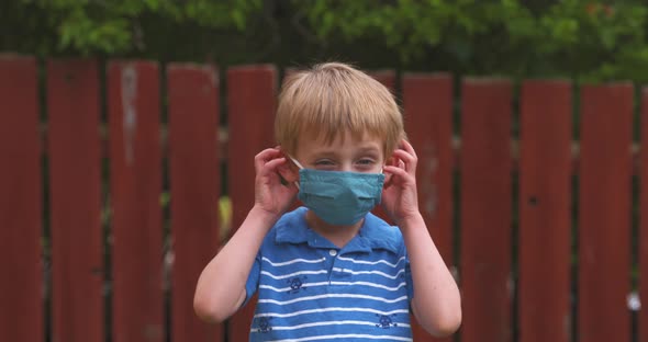 Happy, smiling little boy res his face mask.